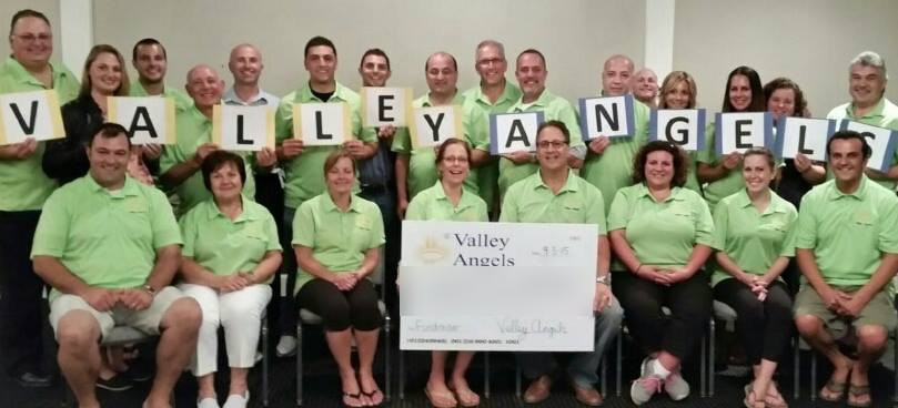 Valley Angels volunteers presenting a check to the family they chose that year